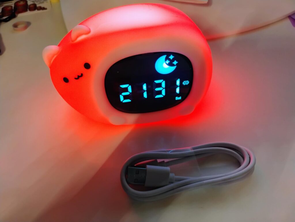 Réveil en forme de chat, éclairé en rouge, avec le câble de chargement
