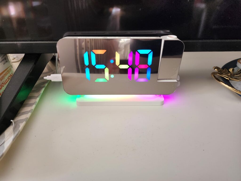 Le réveil sur un bureau, l'heure est affichée en plusieurs couleurs et la base est éclairée en rouge, vert, bleu et violet. O...