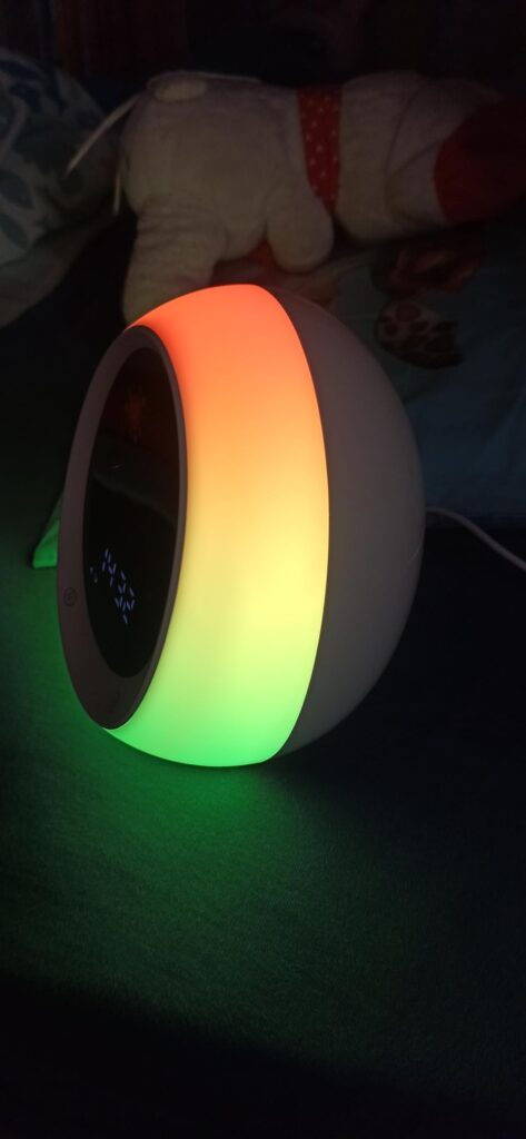 Réveil allumé, affichant l'heure, avec un halo multicolore