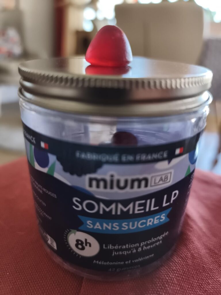 Pot de Mium Lab Sommeil LP avec un bonbon gomme dessus, posé sur un tissu.