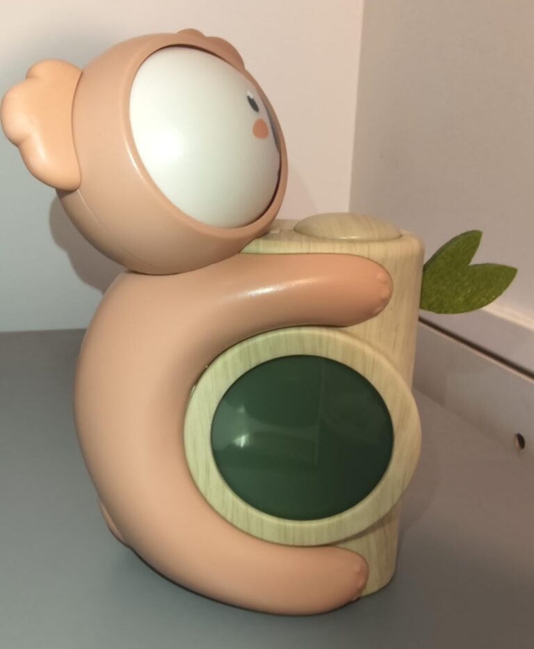Vue de côté du réveil Koala, montrant l'écran de l'horloge et la feuille décorative.