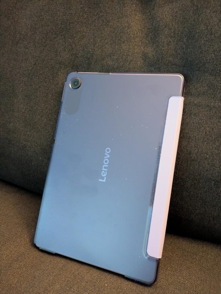 Tablette grise dans son étui, vue de dos. Même visuel que le 0 sous un angle différent.