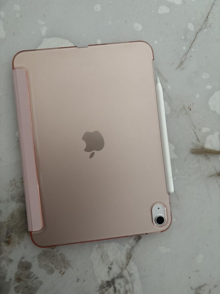 Vue de dessus d'une tablette iPad Mini 6e génération, de couleur rose doré, protégée par une coque-clavier de couleur rose. U...