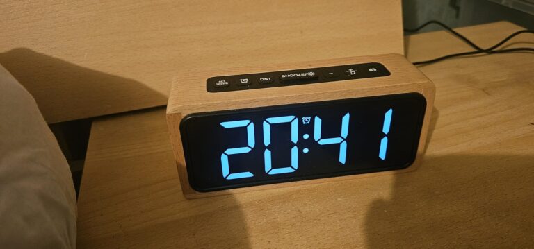 Réveil posé sur une table de chevet, affichant l'heure 20:41