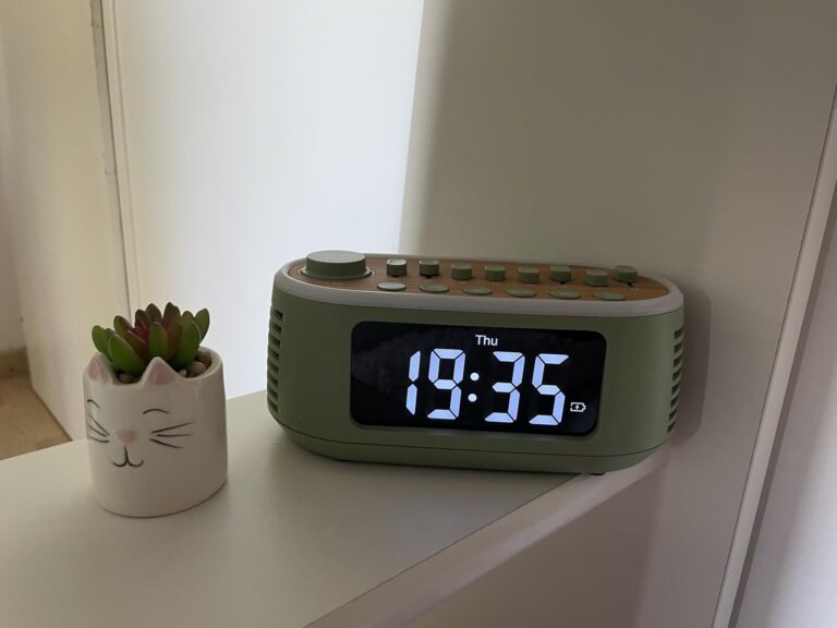 Le réveil sur une étagère à côté d'une plante. L'heure affichée est 19:35.