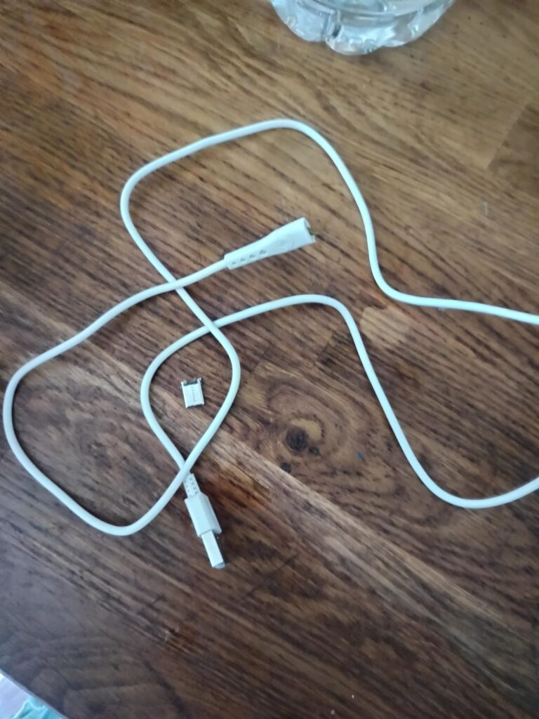 Le câble USB-C est cassé, le connecteur est détaché du câble. Même chose que le visuel 0, avec plus de recul.