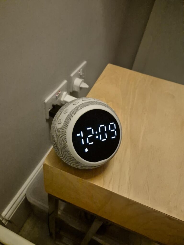 Le réveil sur une table de chevet avec l'heure 12:09 affichée