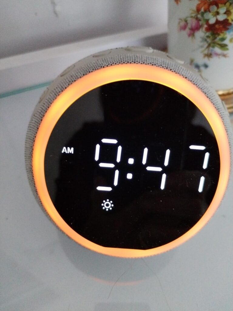 Gros plan sur le réveil affichant 9:47 avec l'option AM et l'icône de luminosité