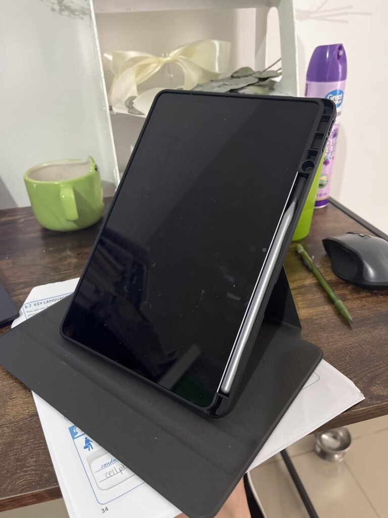 Tablette noire sur un support dans un intérieur, vue de face.