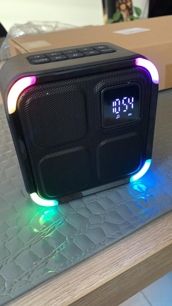 Vue en situation du produit sur une table, avec les lumières LED des coins allumées et colorées.