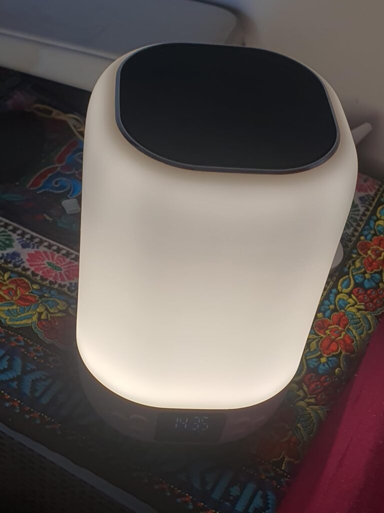 L'appareil est allumé, posé sur une table. C'est le même angle que le visuel 0, mais avec une lumière différente et un arrièr...