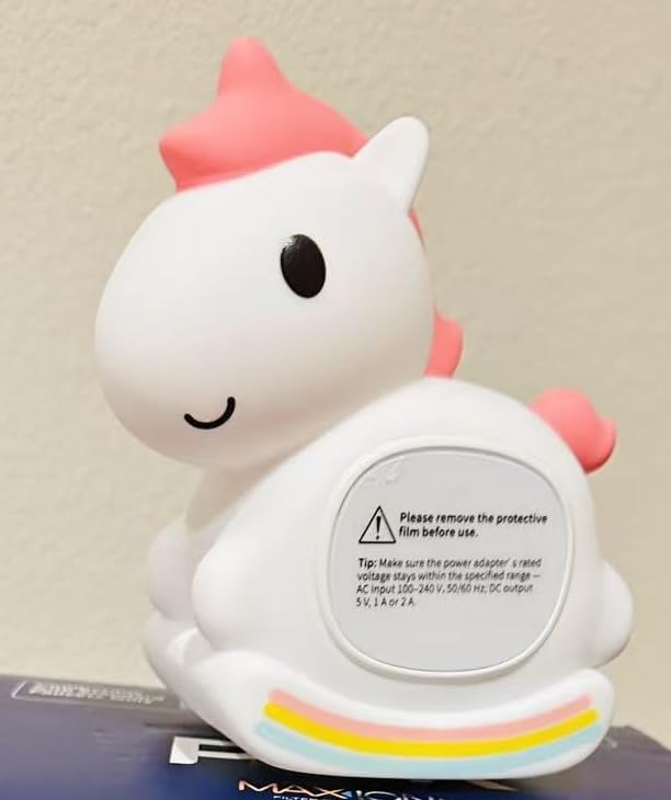 La licorne avec un autocollant d'avertissement sur son ventre, sur un fond uni.