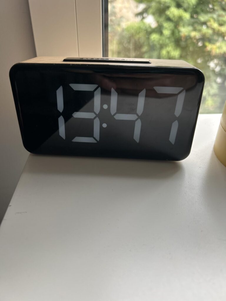 L'horloge pos'e sur un rebord de fenêtre, affichant l'heure.
