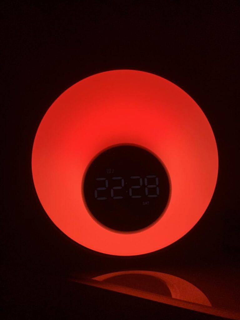 Vue rapprochée du réveil lumière affichant l'heure et une lumière rouge.