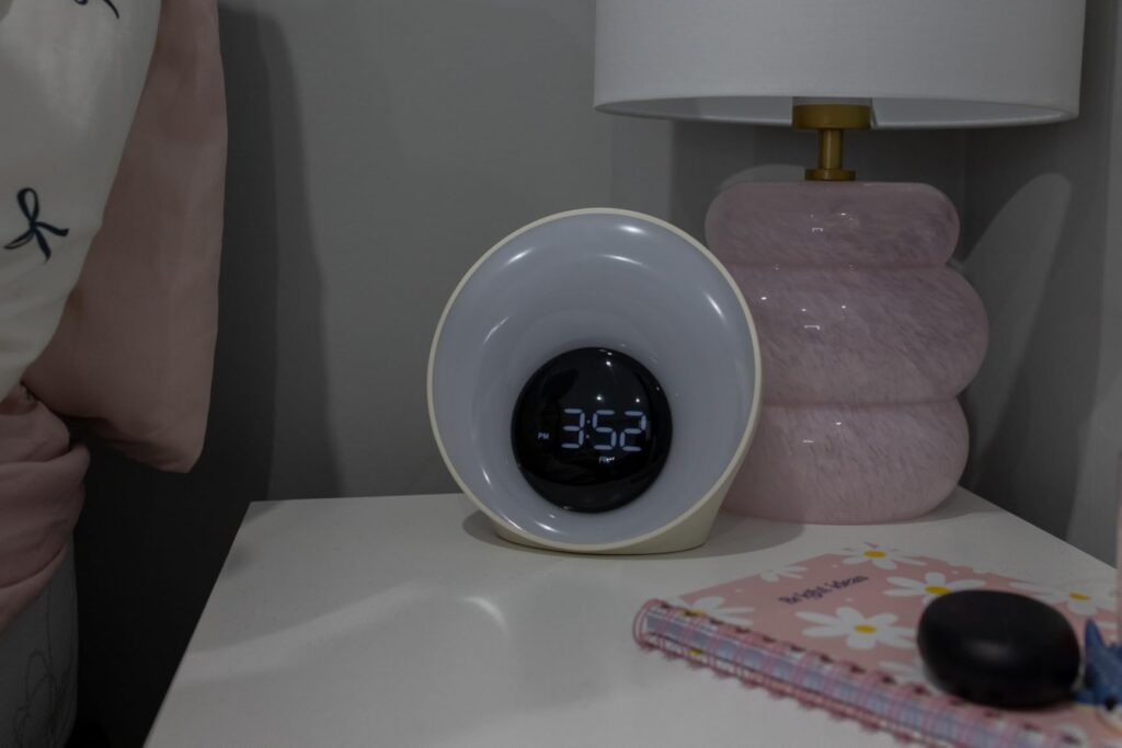 Le réveil lumière sur une table de chevet avec l'heure affichée.
