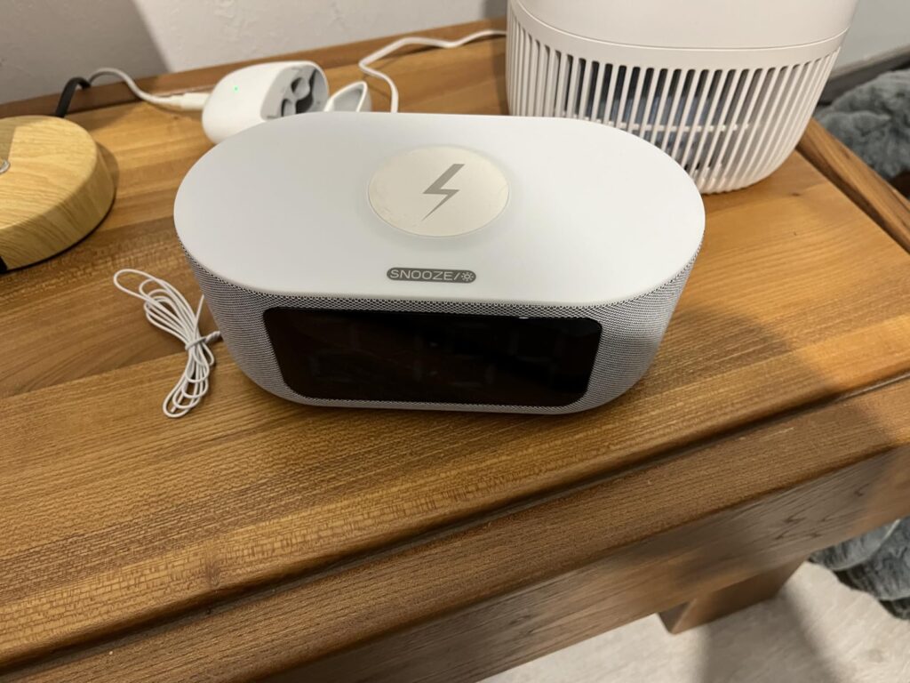 Le radio réveil sur une table de nuit, vue de dessus, montrant le chargeur sans fil.