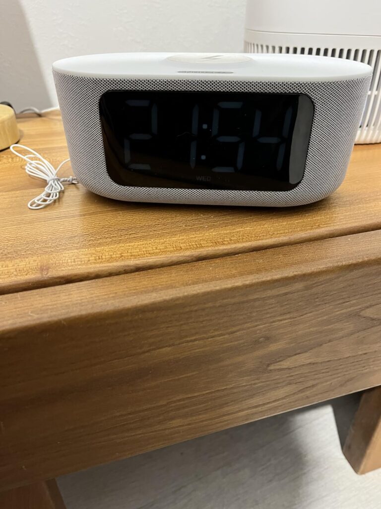 Le radio réveil sur une table de nuit, affichant l'heure.