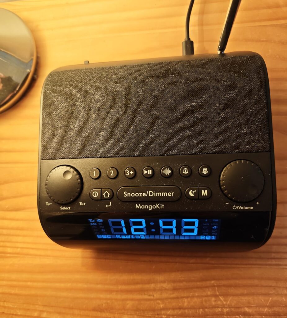 Radio-réveil sur une table, vue de dessus en légère plongée, l'antenne n'est pas visible