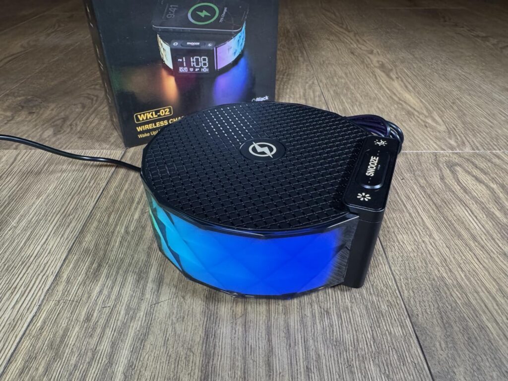 Le radio-réveil et son emballage vus en plongée, avec un éclairage bleu activé.
