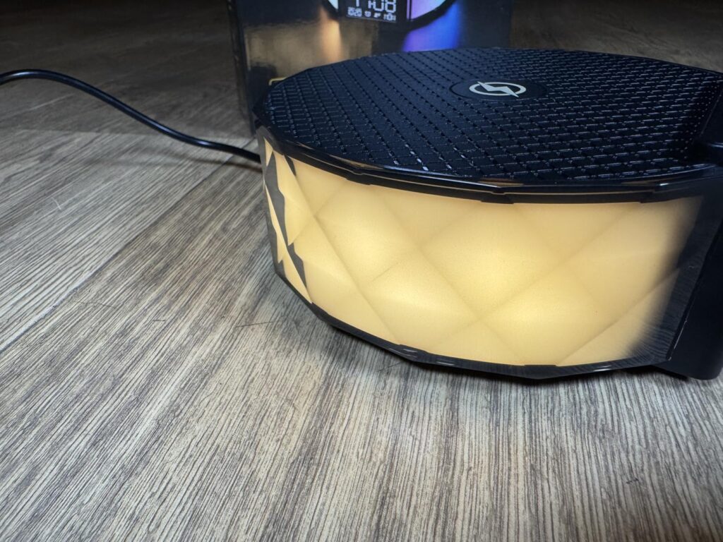 Gros plan sur l'éclairage latéral du radio-réveil, de couleur jaune.
