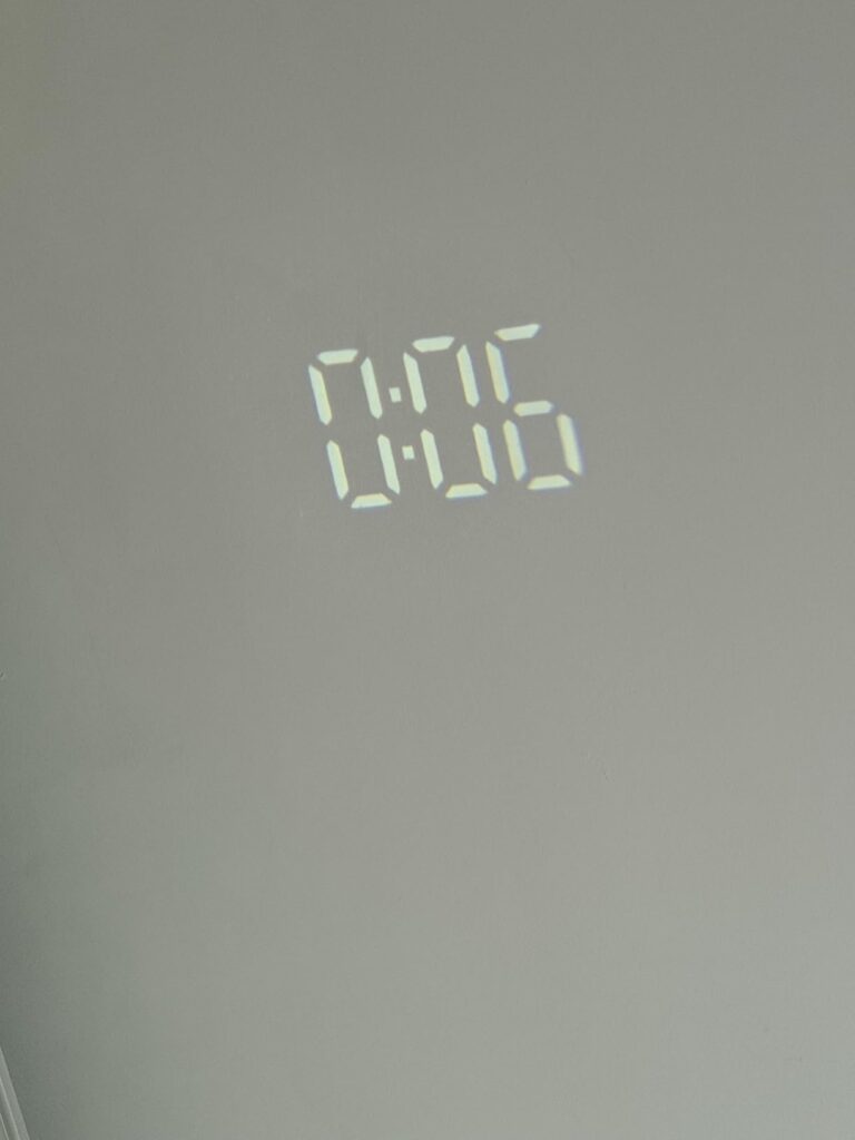 Photo de l'horloge projetant l'heure sur un mur blanc.