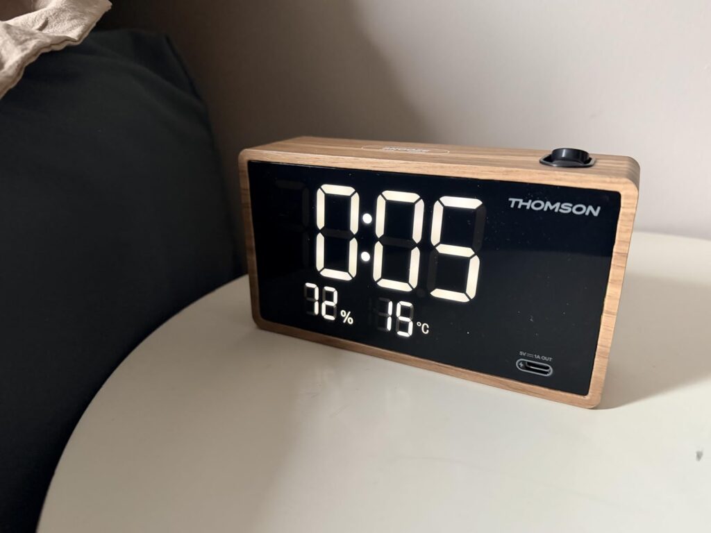L'horloge sur une table de chevet, affichant l'heure, l'humidité et la température.