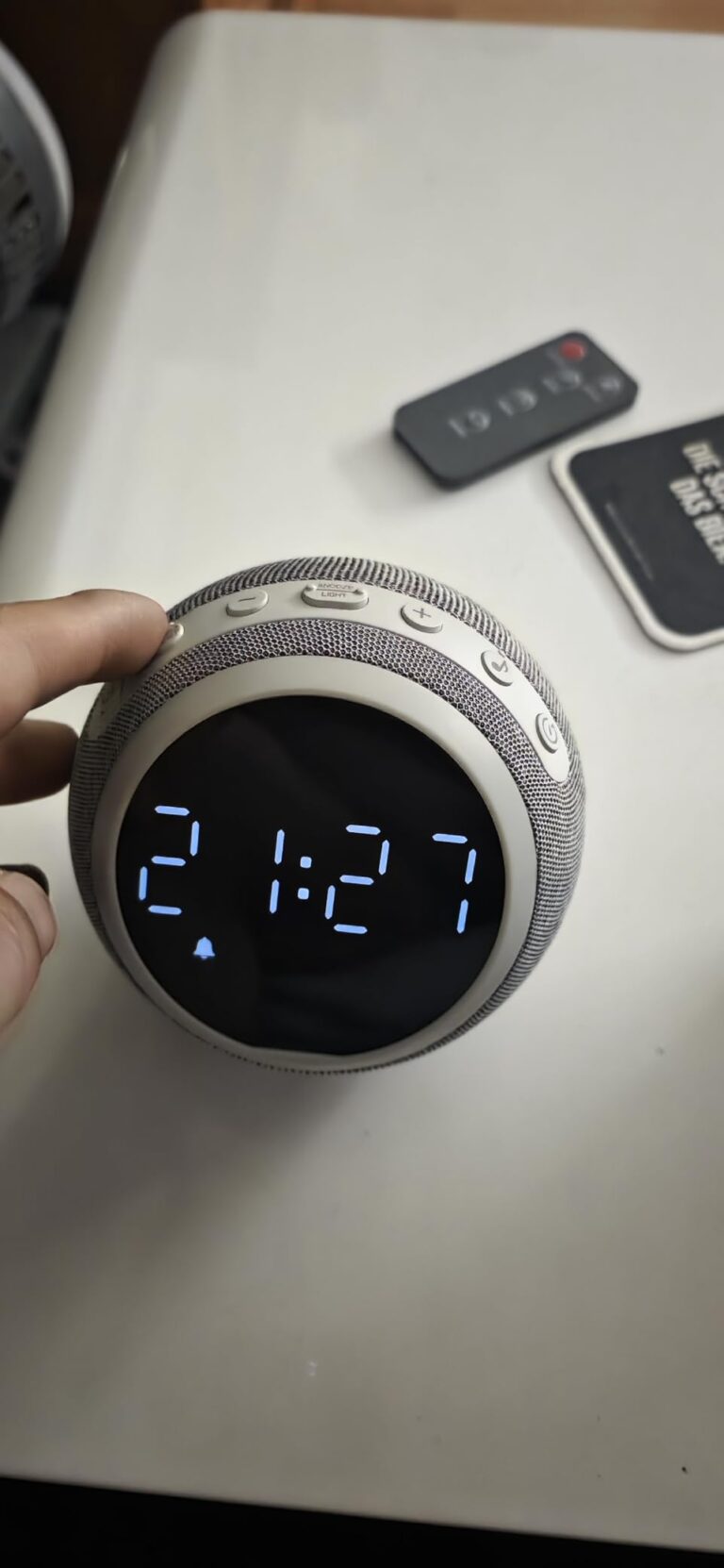 L'enceinte sur une table, avec une télécommande en arrière-plan. L'heure 2:17 est affichée.