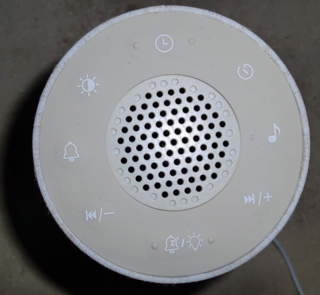 Vue de dessus montrant les boutons de contrôle tactiles et la grille du haut-parleur.