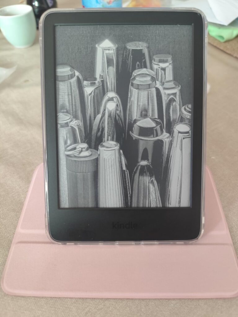 Liseuse Kindle sur une table, dans son étui ouvert, en position verticale.