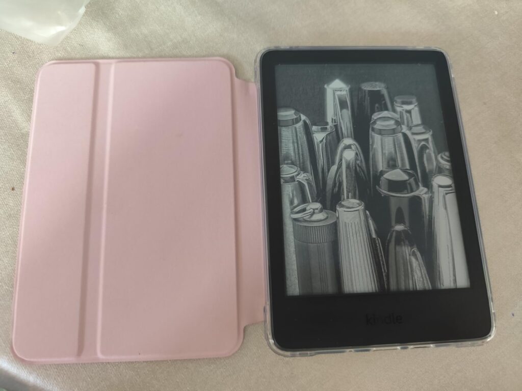 Liseuse Kindle sur une table, dans son étui ouvert, posée à plat.