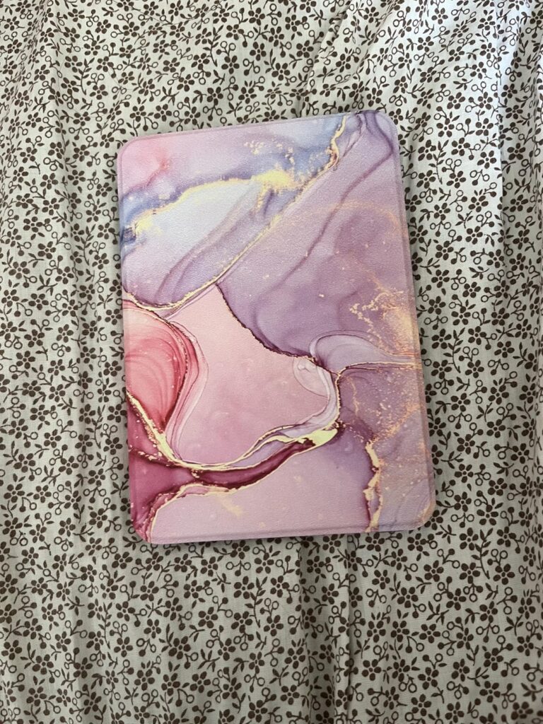 Vue de l'étui de protection pour liseuse Kindle Paperwhite, avec un motif abstrait marbré aux tons rose, violet et doré, posé...