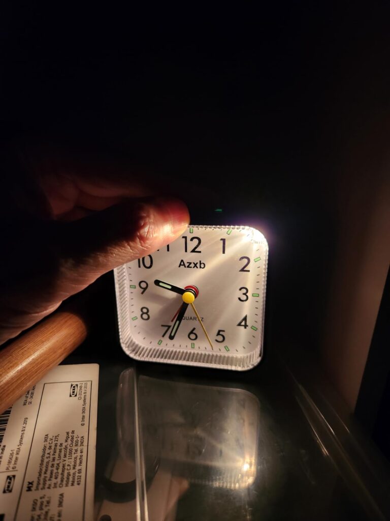 Vue de face du réveil dans l'obscurité avec le bouton de la lumière activé.