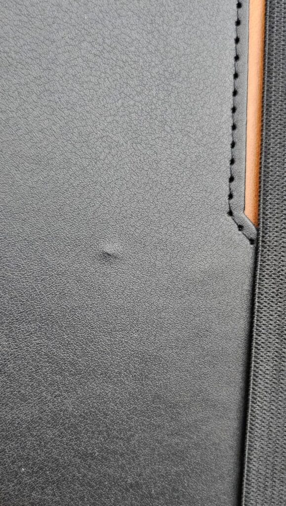 Gros plan sur l'intérieur de la coque, de couleur grise foncée, montrant une petite bosse sur le revêtement.