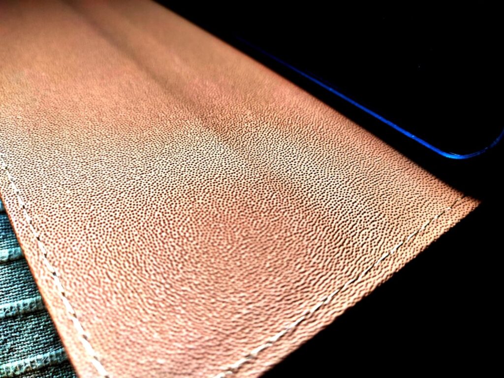Gros plan sur la coque ouverte, montrant la texture du matériau. La coque est de couleur rose pêche.