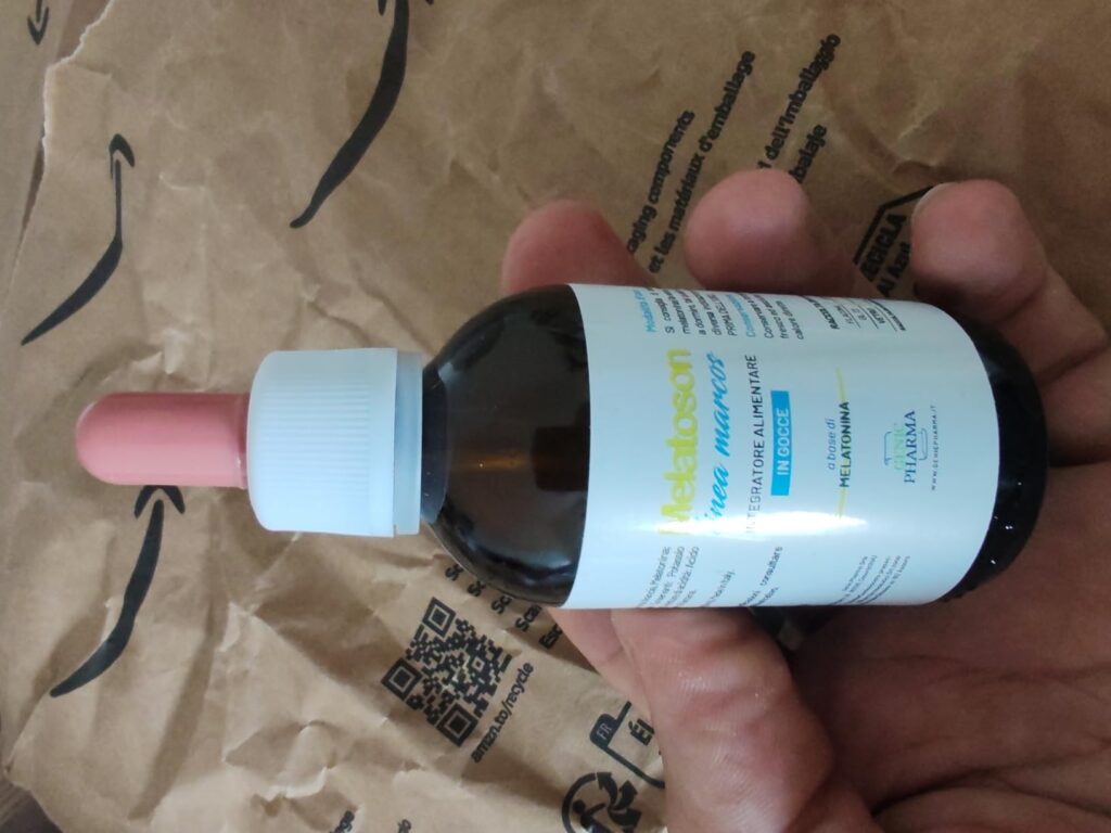 Flacon compte-gouttes avec son étiquette, posé sur un sac Amazon.